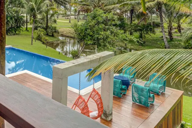 Deck entregue com pórtico de concreto, cadeiras suspensas e piscina, no Condomínio Txai