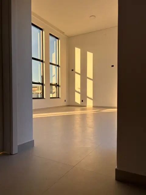 Sala iluminada pelo sol através de janelas altas