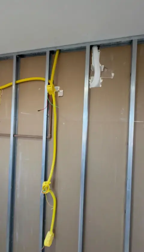 Cabos elétricos passando pela estrutura de drywall antes do fechamento