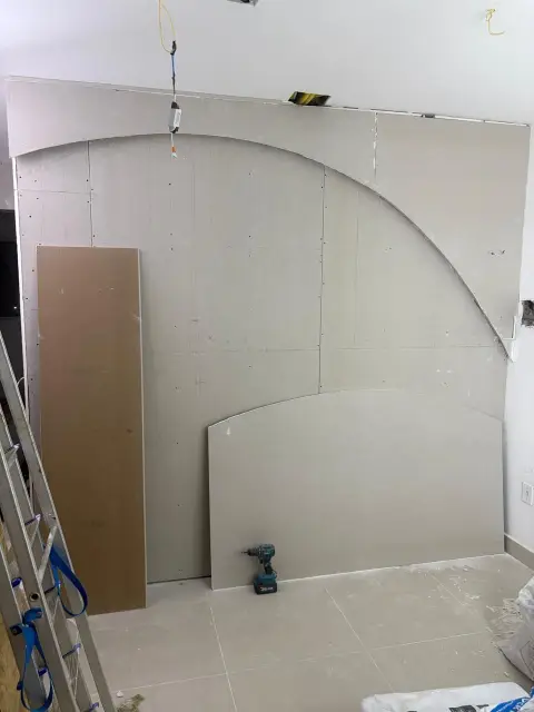 Recepção em obra no Edifício Premier, Ilhéus: parede curva em drywall recém-fechada