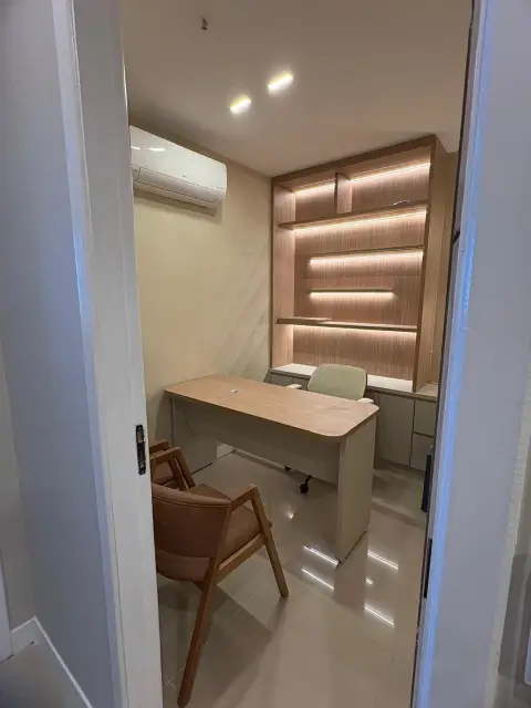 Sala privativa com estante em madeira iluminada