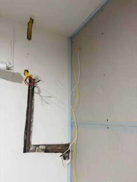 Sala privativa em obra: drywall aberto com eletroduto e fiação expostos